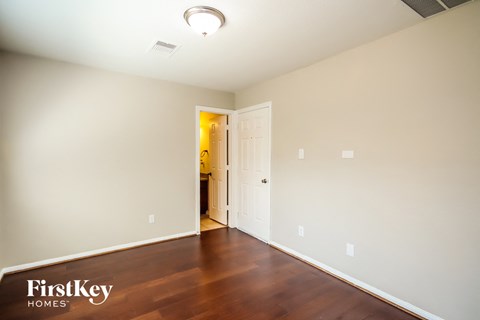 a living room with wood flooring and a door to a hallway