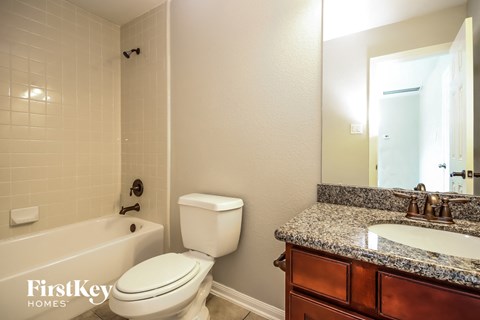 a bathroom with a toilet sink and tub and a mirror