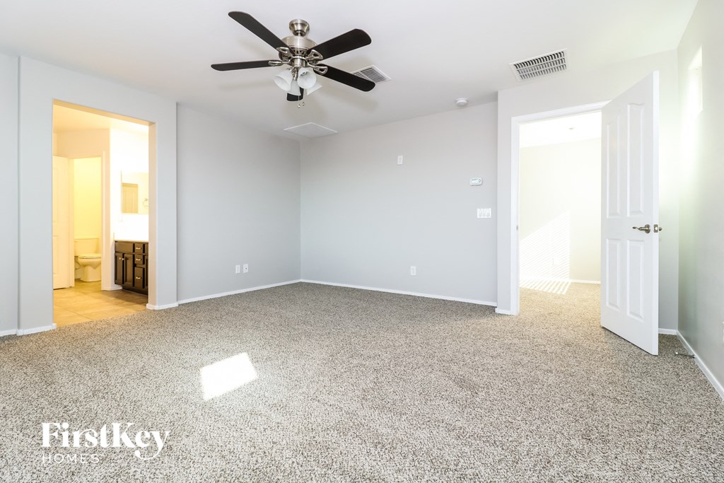 a bedroom with a ceiling fan and a carpeted floor