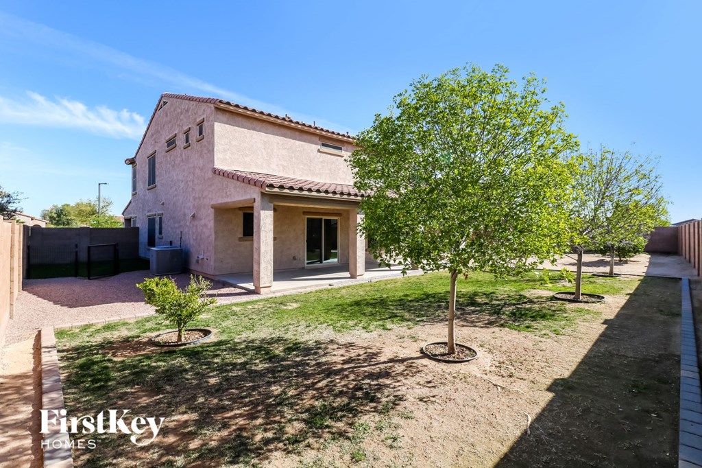 a house with a yard and trees in front of it