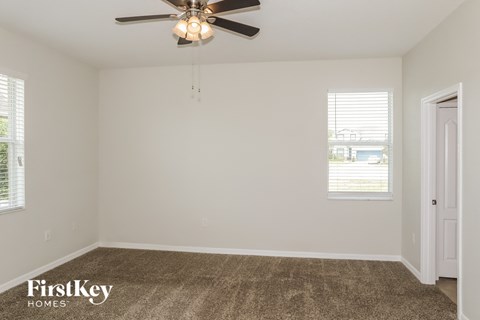 a living room with carpet and a ceiling fan