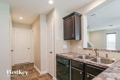 A kitchen with a sink, dishwasher and a cabinet.