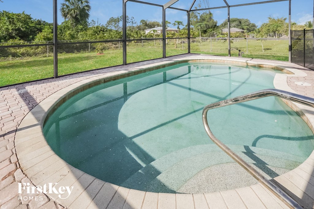 A small pool with a glass enclosure and a metal fence.
