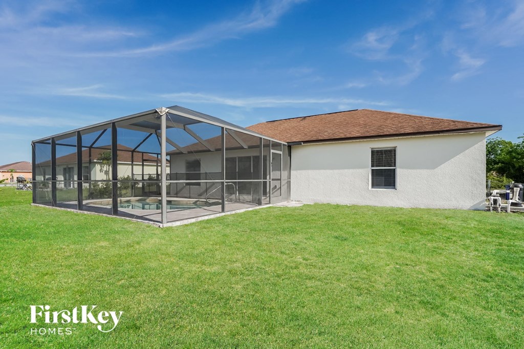 A house with a white exterior and a glass enclosed patio area.