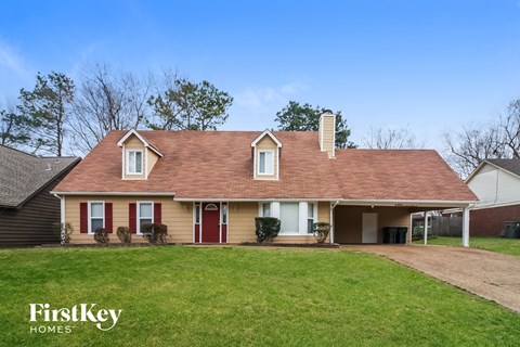 A house with a red door and a chimney is for sale.