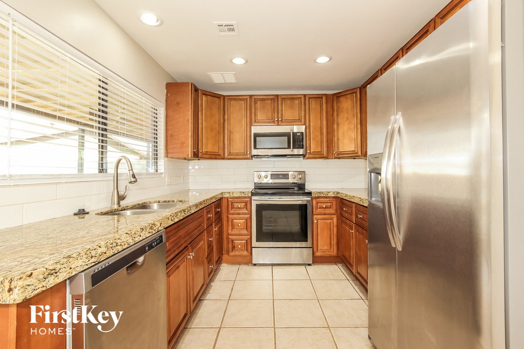 a kitchen with wooden cabinets and stainless steel appliances