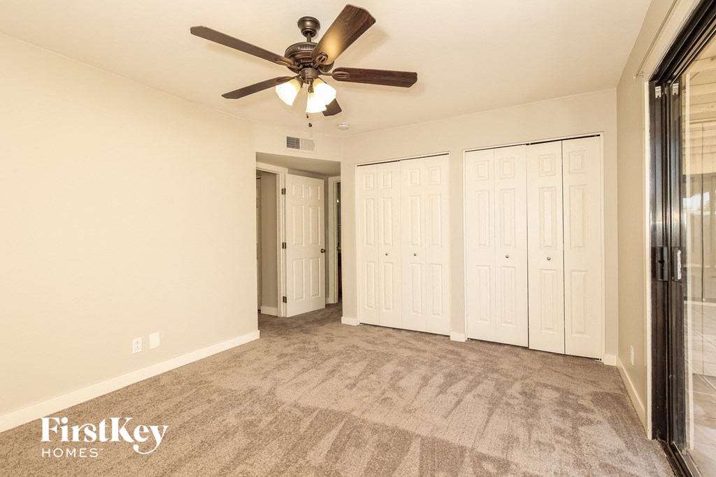 the living room of an empty house with a ceiling fan