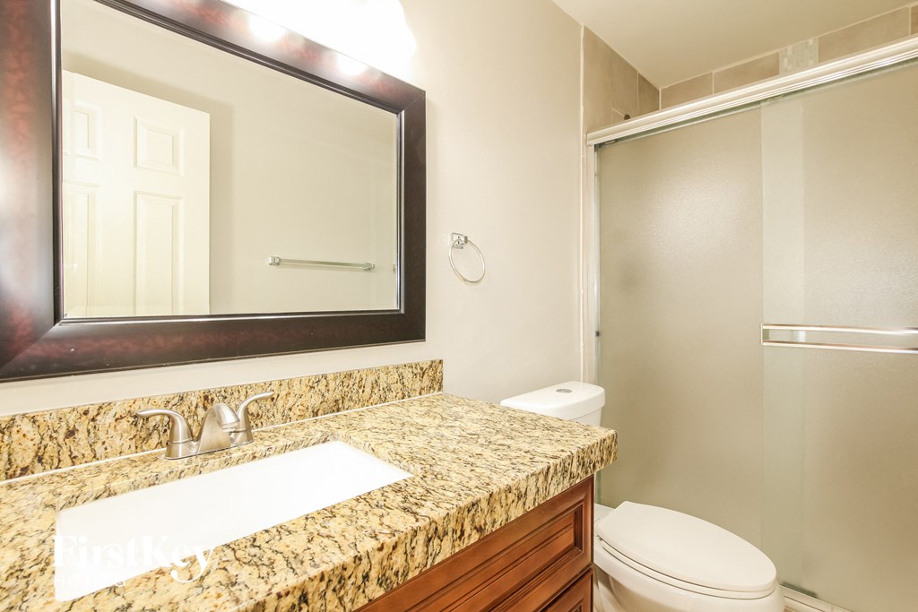 a bathroom with a sink toilet and a mirror