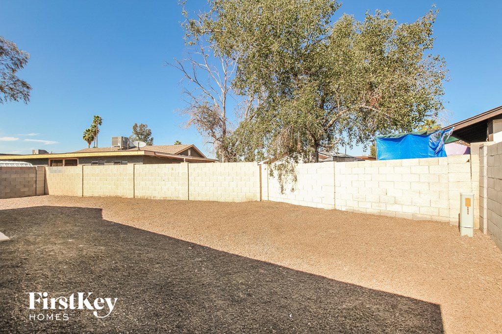 the backyard of a house with a fence and a tree