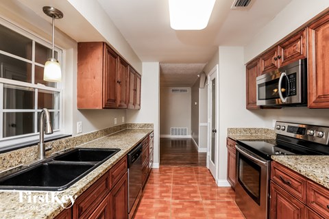A kitchen with wooden cabinets and granite countertops.
