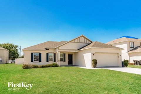 A house with a white garage door and a brown roof is shown.