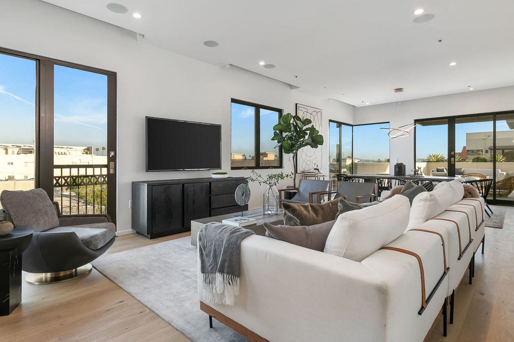 A modern living room with a large white sofa and a flat screen TV.