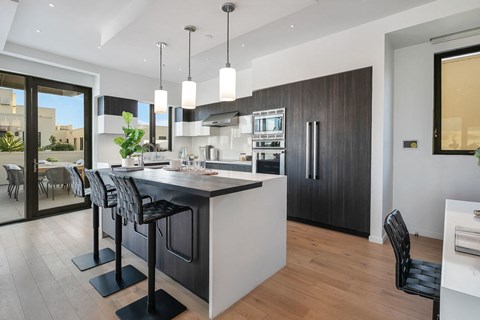 A modern kitchen with a bar area and a dining table.
