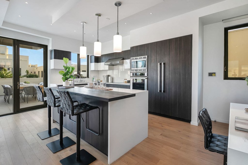 A modern kitchen with a bar area and a dining table.
