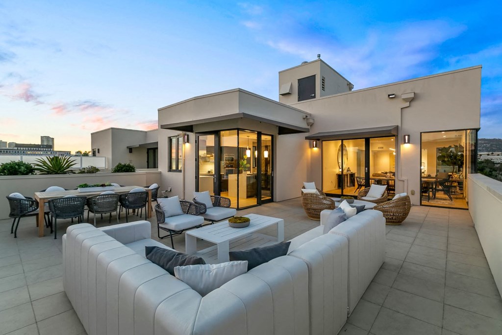 A modern house with a white exterior and a large outdoor seating area.