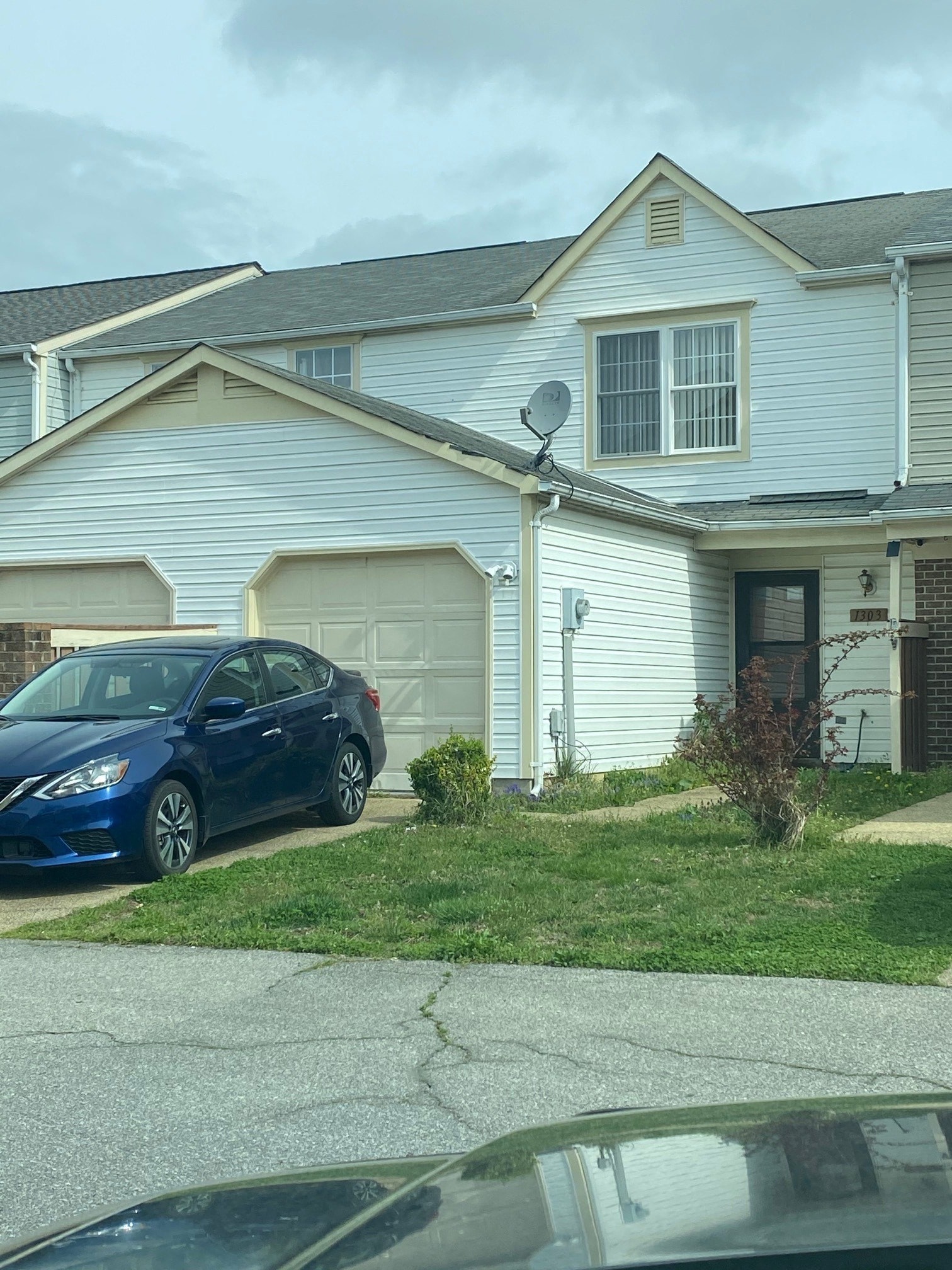 a blue car parked in front of a house