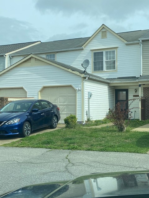 a blue car parked in front of a house