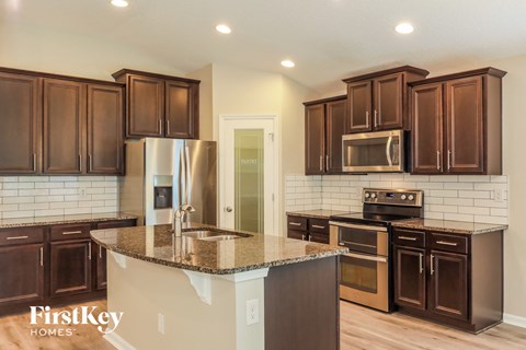 A kitchen with brown cabinets and a granite countertop.