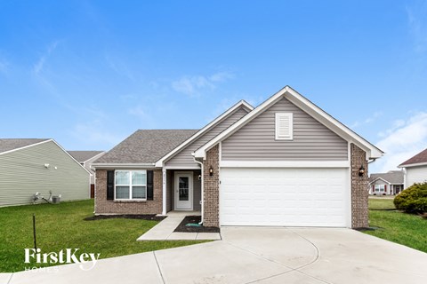 a home with a white garage door and a brick house