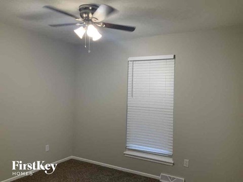 a living room with a ceiling fan and a window