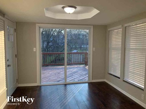 an empty living room with a sliding glass door to a deck