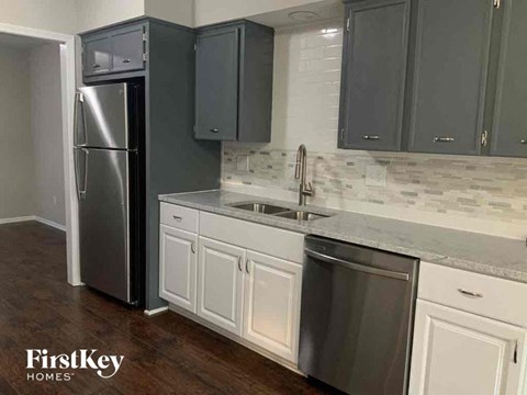 a kitchen with white cabinets and a stainless steel refrigerator