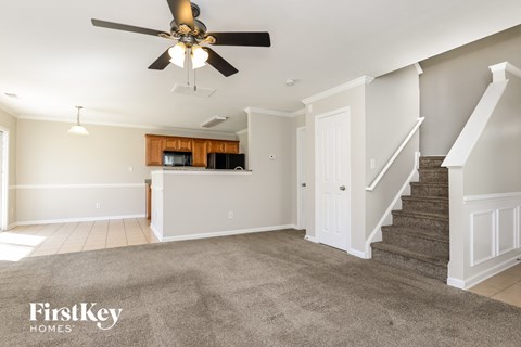 A spacious living room with a staircase leading to the upper floor.