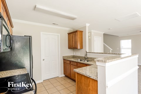 A kitchen with a granite countertop and wooden cabinets.