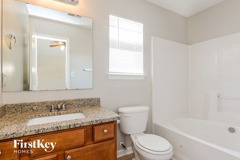 A white toilet sits next to a sink in a bathroom.