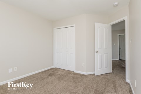 A room with two doors and a carpeted floor.