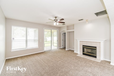 a living room with a fireplace and a ceiling fan