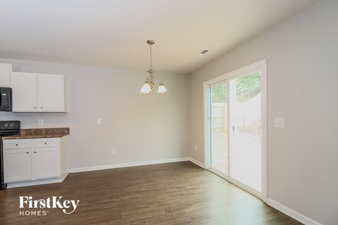 a kitchen and dining room with white cabinets and wood flooring