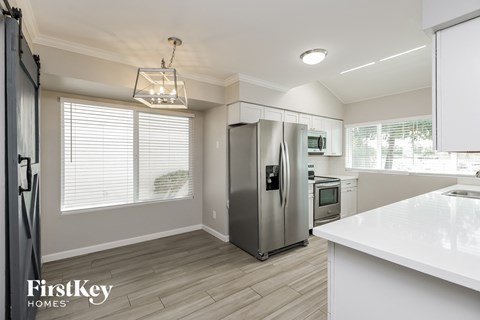 a white kitchen with stainless steel appliances and a white counter top