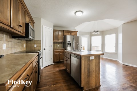 A kitchen with wooden cabinets and a large island.
