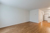 an empty living room with white walls and wooden floors