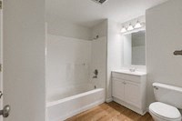 a bathroom with a toilet and a tub and a sink