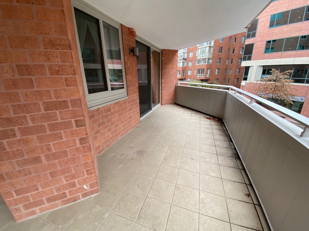 a balcony with a brick wall and a large window