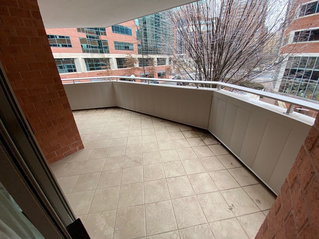 a balcony with a view of the city and a tile floor