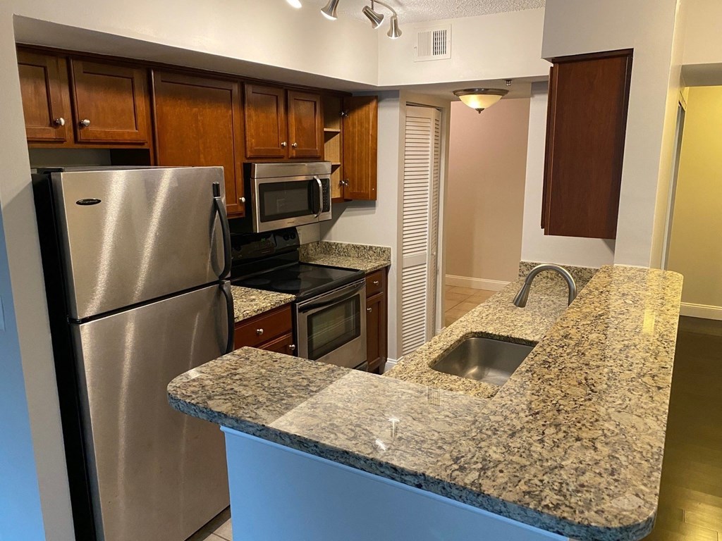 a kitchen with granite counter tops and stainless steel appliances