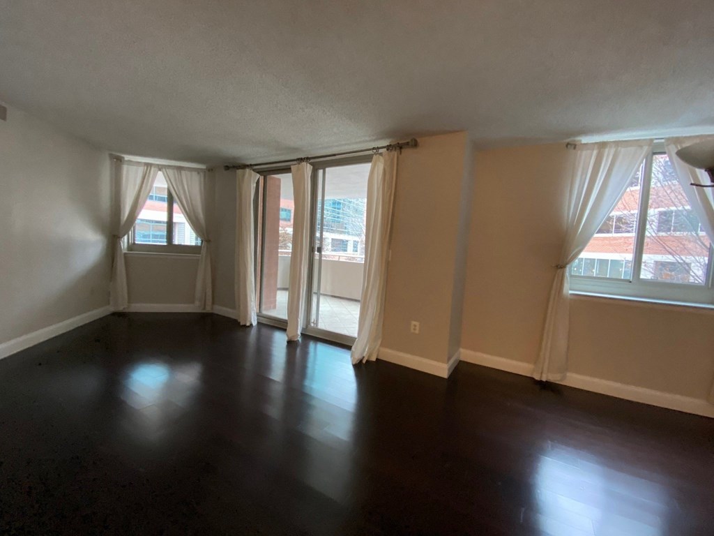 an empty living room with windows and curtains