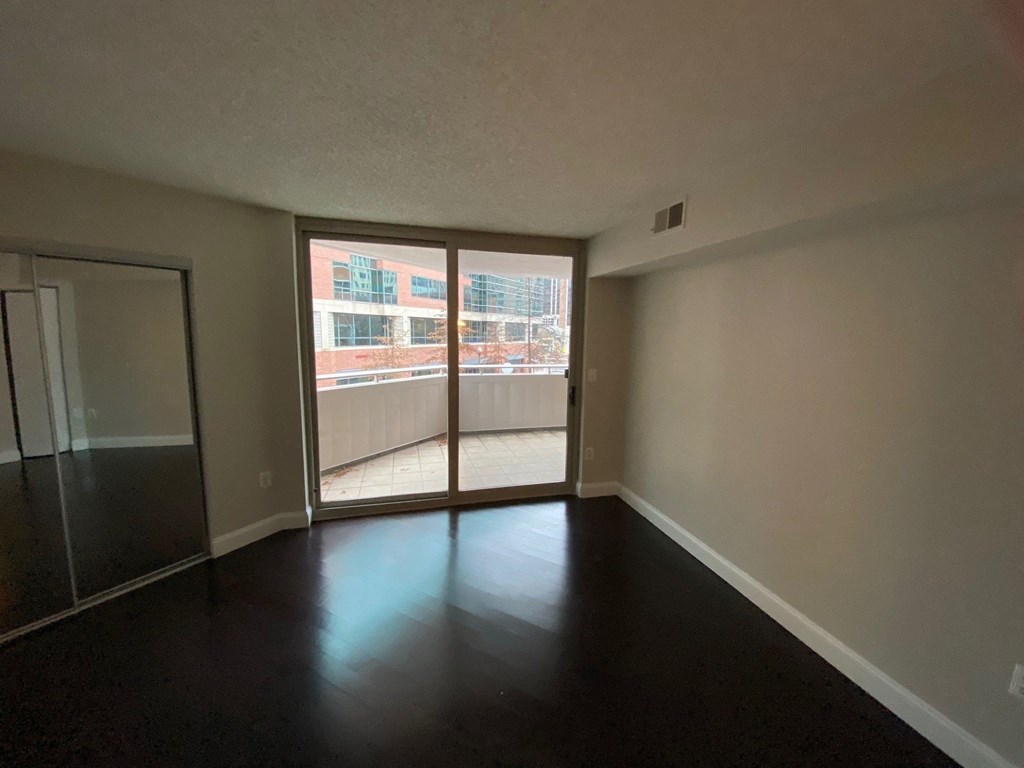 an empty living room with sliding glass doors to a balcony