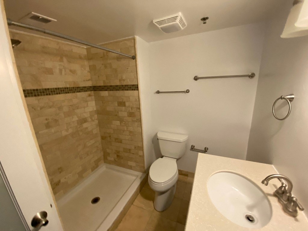 a bathroom with a shower toilet and sink