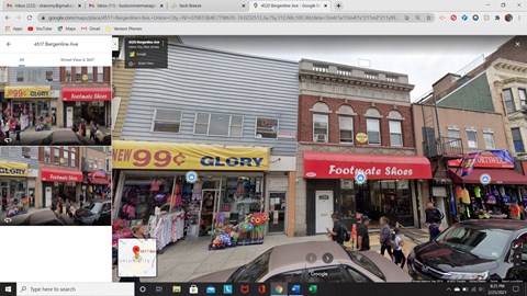 A street view of a shopping area with various stores including a shoe store.