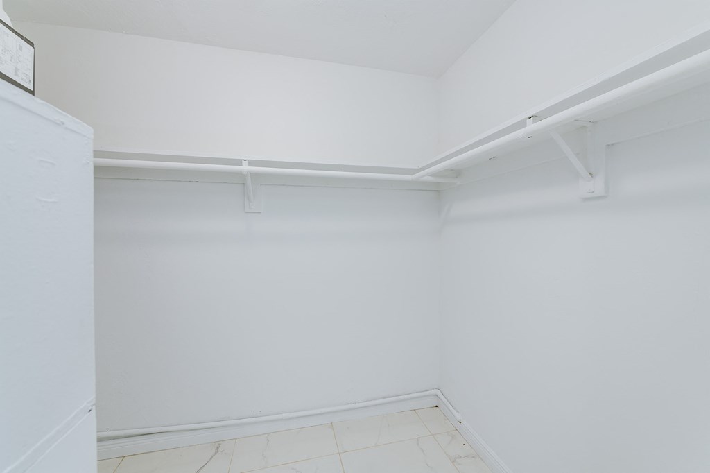 an empty room with white walls and a white closet