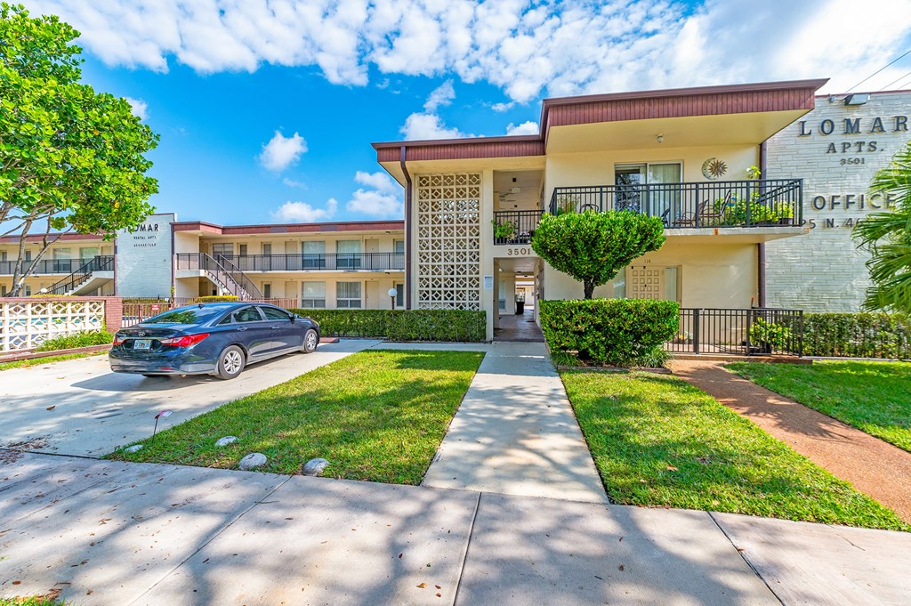 an apartment building with a car parked in front of it
