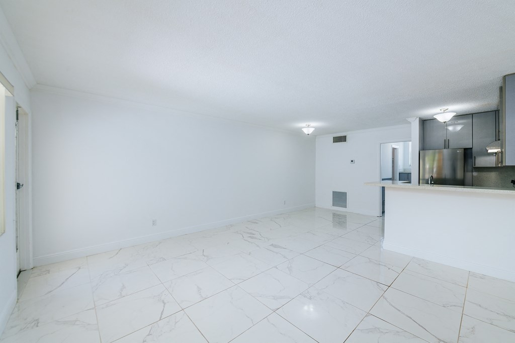 the living room and kitchen of an empty apartment