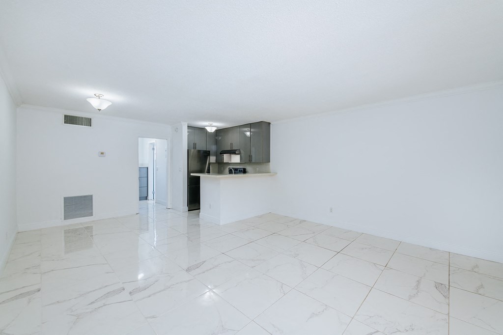 the living room and kitchen of an empty apartment