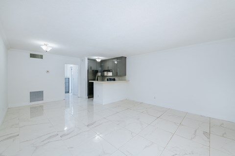 the living room and kitchen of an empty apartment
