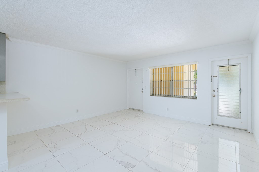 the living room and dining room of an empty apartment