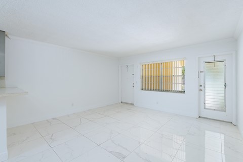 the living room and dining room of an empty apartment